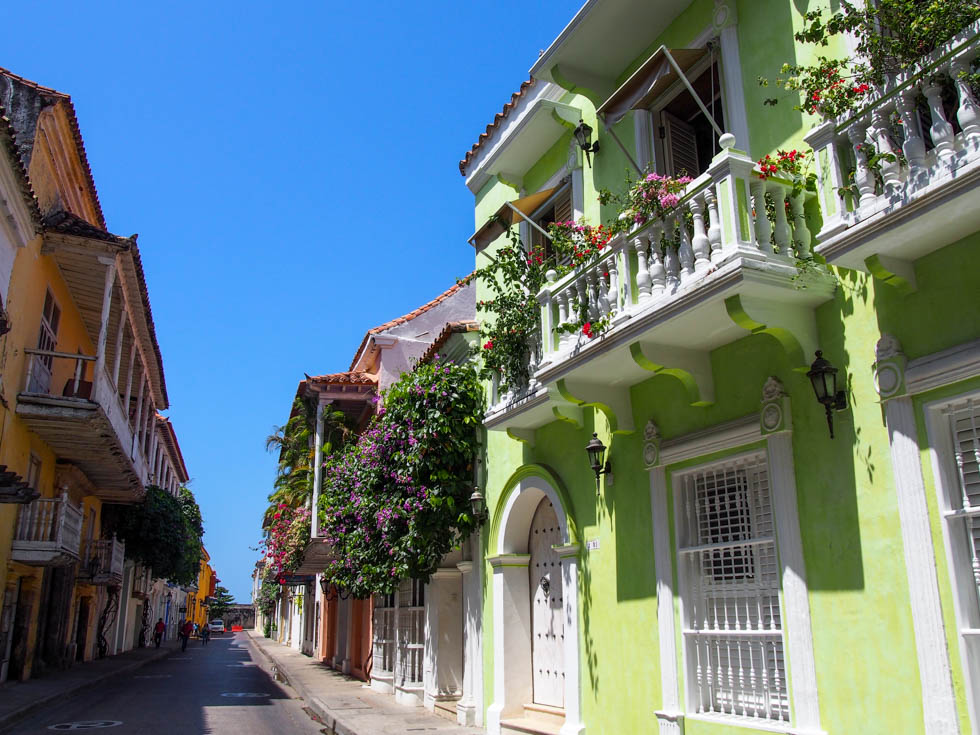 Sunny street with colorful homes and flowerpots in Cartegena, Colombia