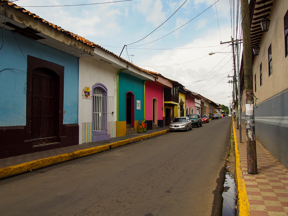 A row of colorfully painted, colonial homes in Leon, Nicaragua on a slightly overcast day