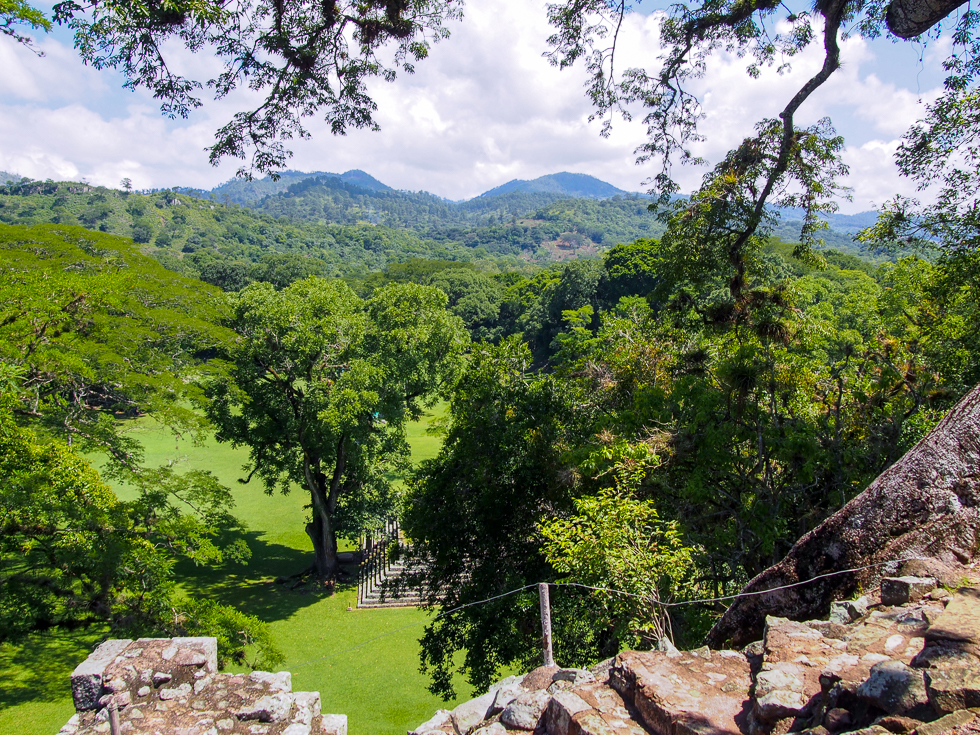 Vista of the Copan Valley, many trees, and mountains in the distance, seen from the top of the Mayan ruins of Copan