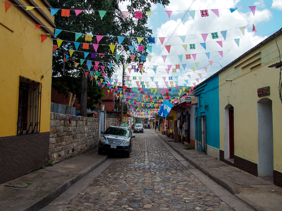 A colorful street in Copan Ruinas, Honduras with an array of flags above the street