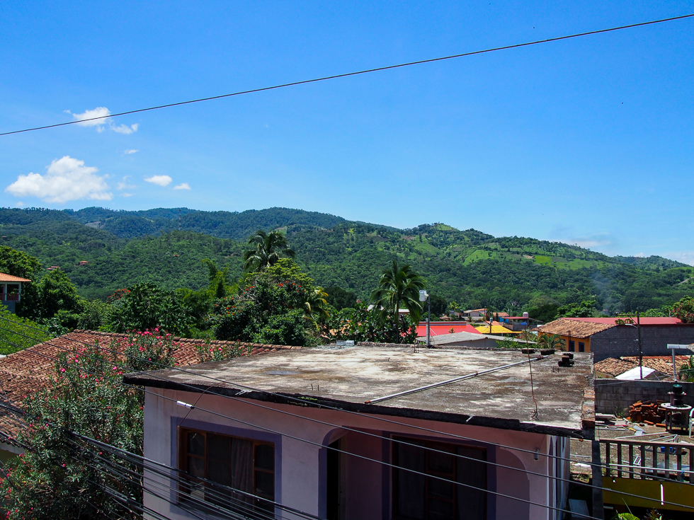 View of some tops of buildings and the hills of Copan in the distance